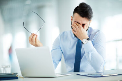 58944785 – businessman rubbing eyes at laptop